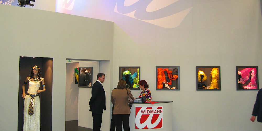 Entwicklung und Ausgestaltung des Messestandes der Firma Widman auf der Spielwarenmesse in Nürnberg. Grauer Corpus mit Vitrinen.