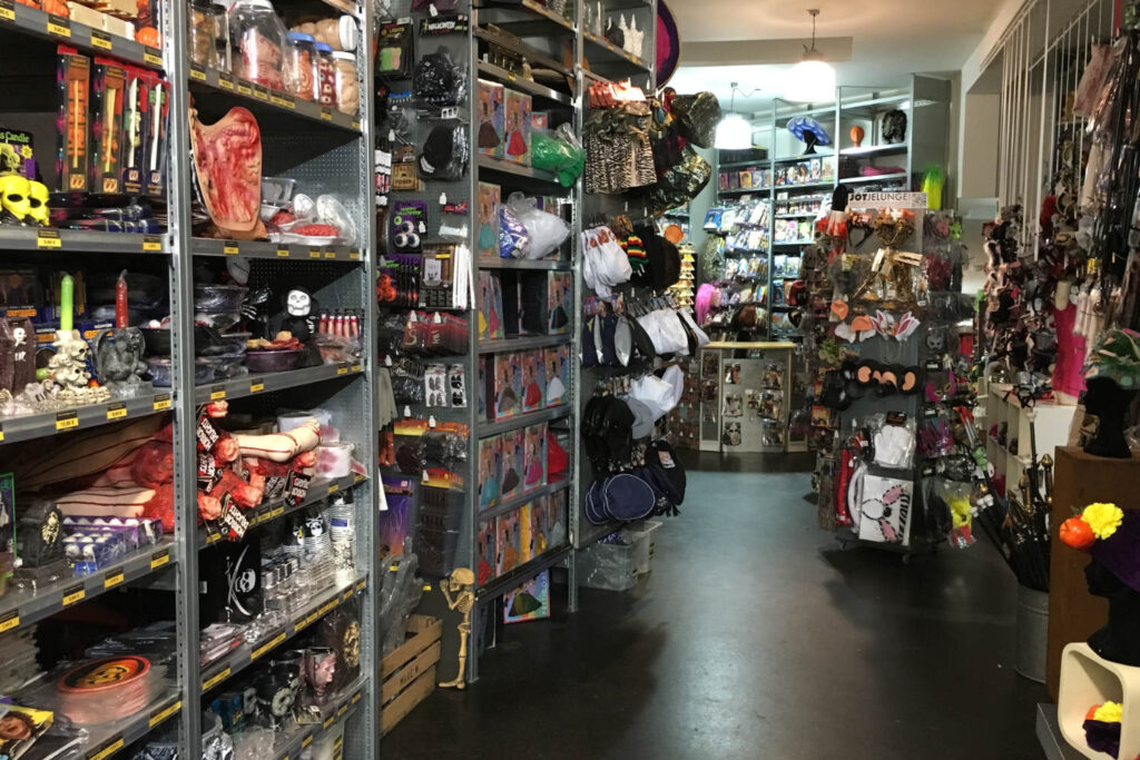 Jot Jelunge im Erdgeschoss neben einem Regal mit Halloween Artikeln