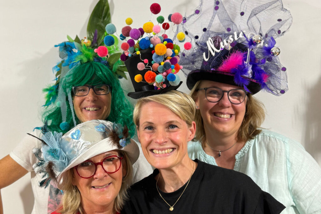 4 Frauen mit DIY gestalteten Hüten und Perücken beim Workshop