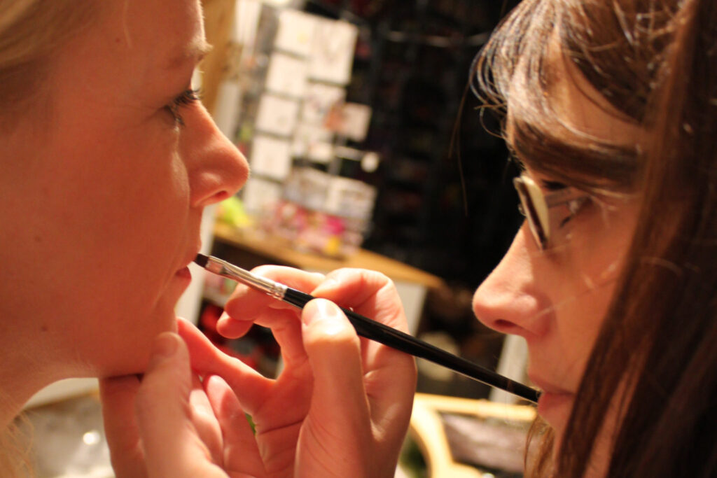 Make up Workshop mit dem Thema Abend Make up. Zu sehen ist unsere Makeup Artist die gerade das Lied Lippen Make-up aufträgt.